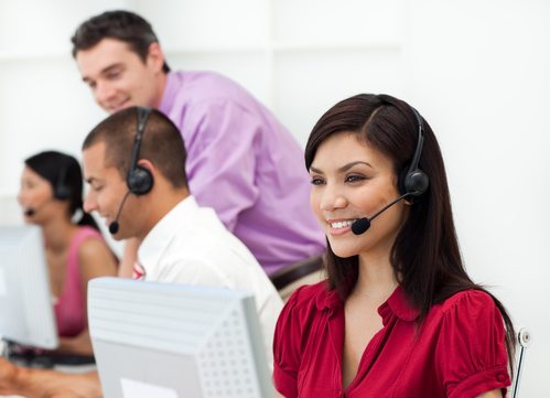 Smiling Customer service representative with headset on in a call center
